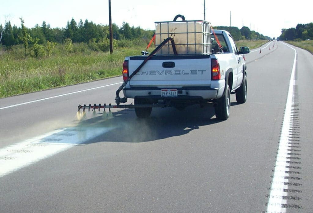 Spraying JointBond on rumble strip.